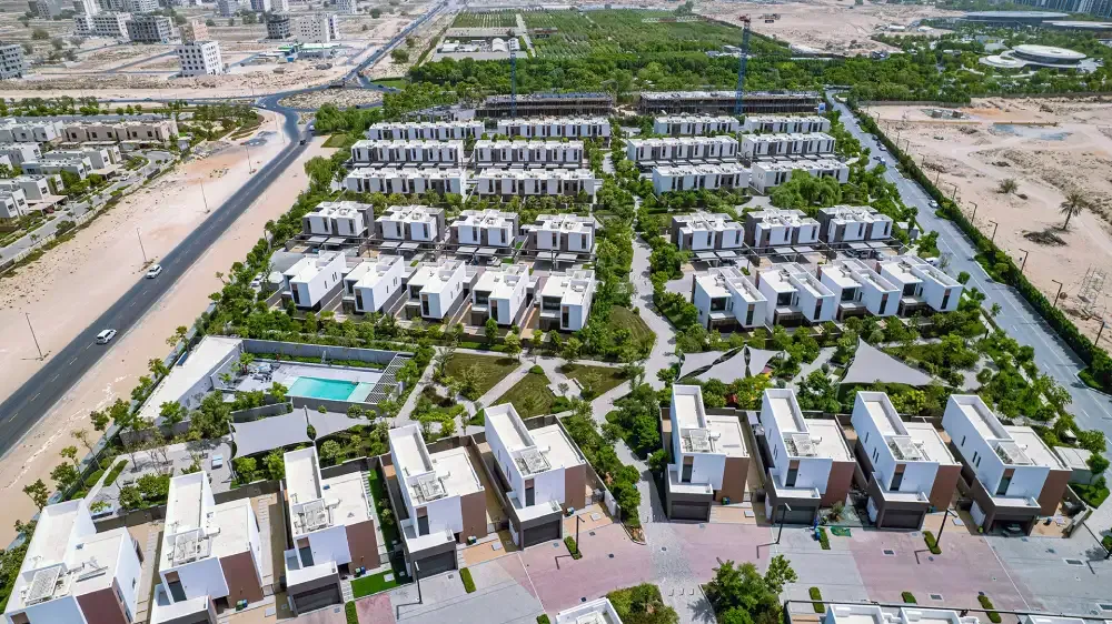 Aerial photo of the Sarab villas and townhouses in Aljada, with a shared pool, planted courtyards and the main road alongside